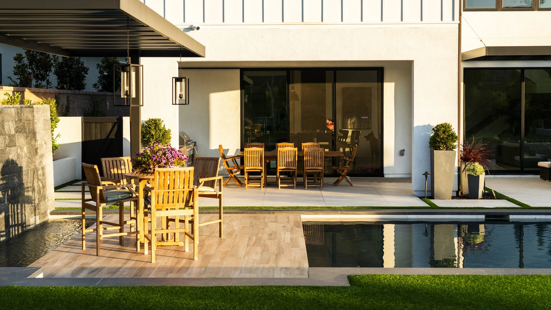 Dining under a louvered pergola beside the pool.